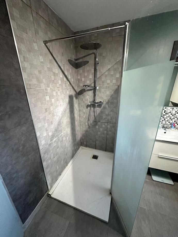 Ancienne douche carrelée avec receveur et colonne avant rénovation