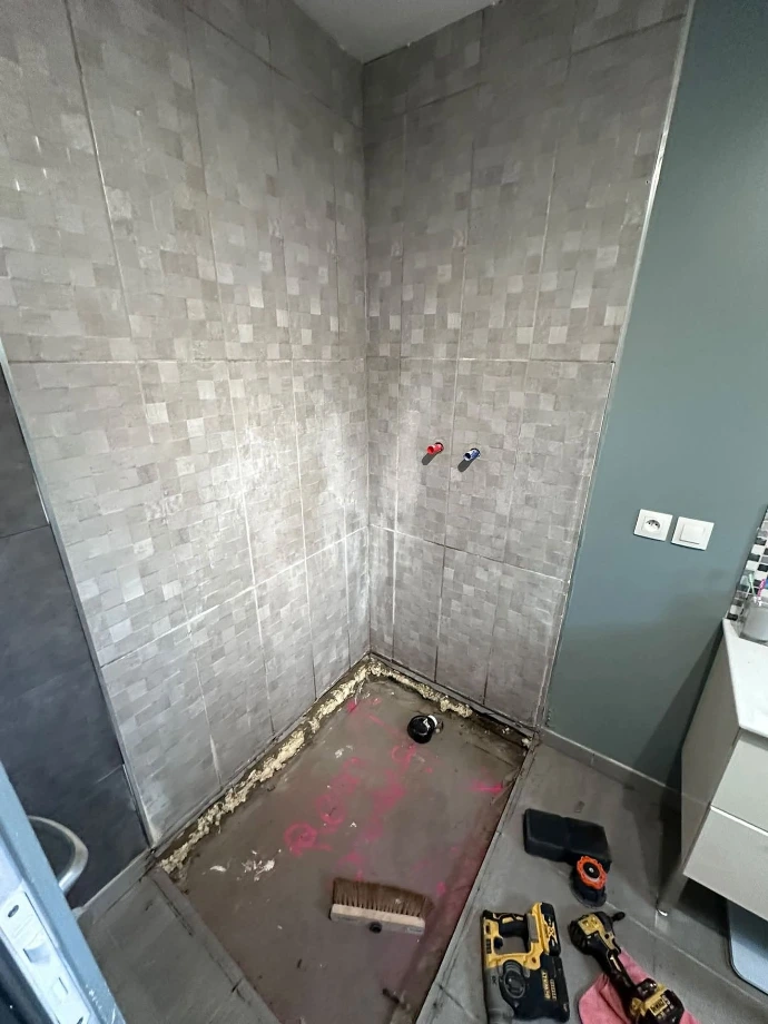 Zone de douche après dépose du receveur, support préparé avant pose des panneaux