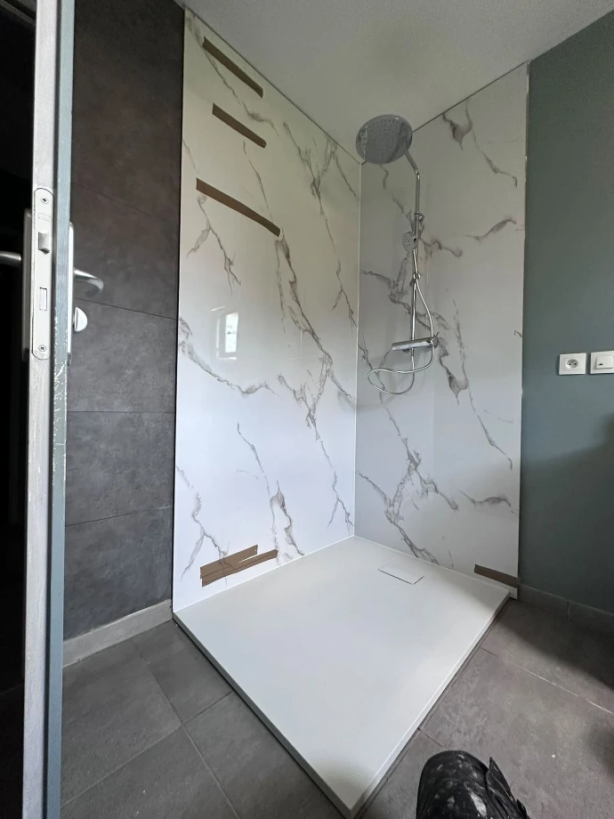 Nouveau receveur de douche posé devant les panneaux muraux effet marbre