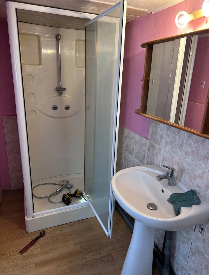 Ancienne cabine de douche vétuste avec receveur surélevé avant rénovation à Rumegies