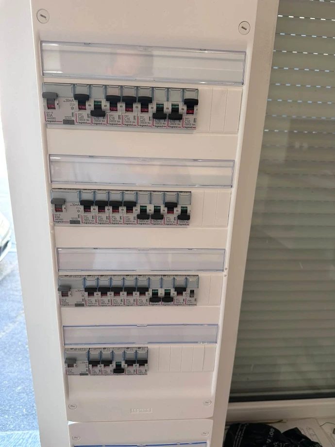 Disjoncteurs et interrupteurs différentiels répartis par rangée dans un tableau électrique