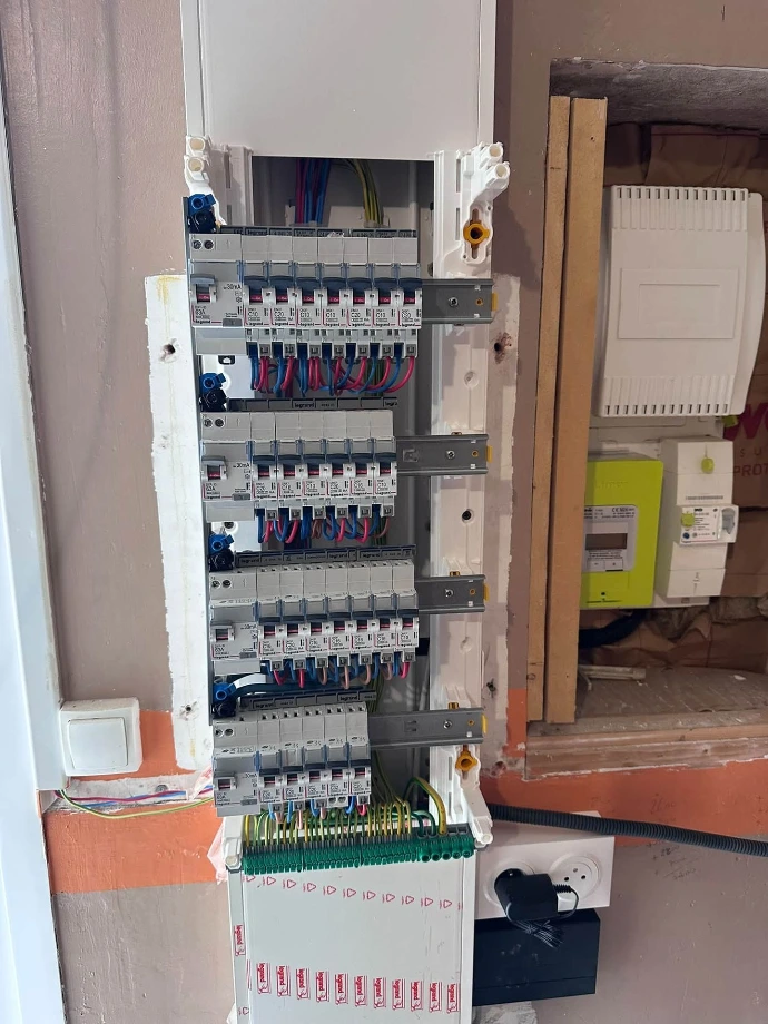 Tableau électrique en cours de reprise, intégré sur une gaine technique logement